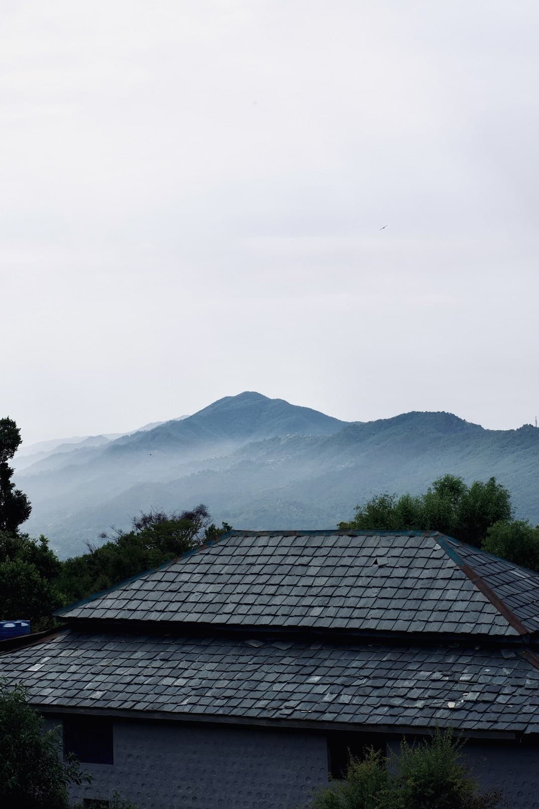Layered mountain ridges above a slate roof
